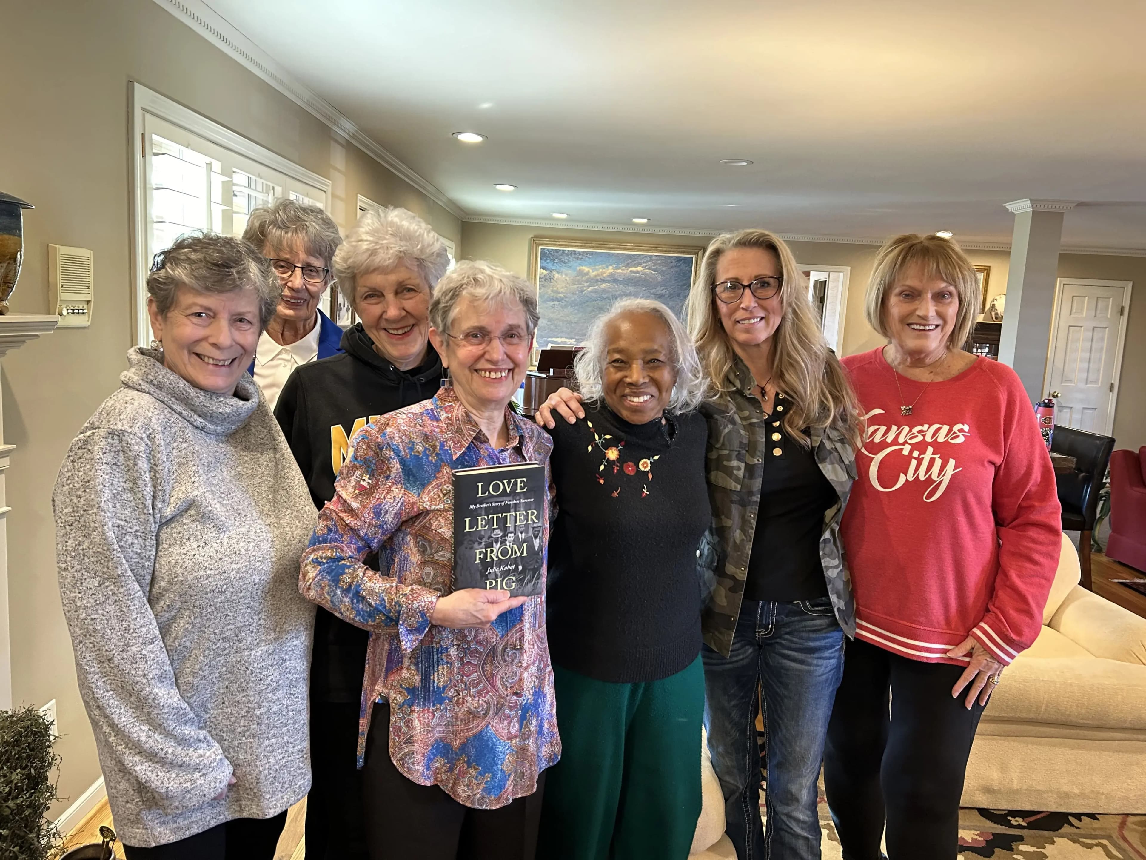 Julie Kabat with a group of readers gathered together, one holding a copy of Love Letter From Pig